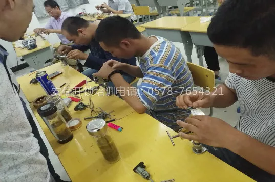 多名学员围在长桌前，桌面摆满锁芯与拆装工具