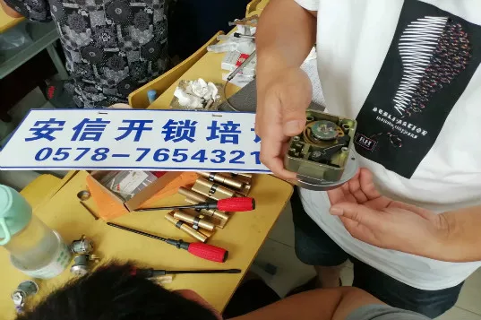 工作台上摊开的锁芯、开锁工具与钥匙胚展示板，学员手持单勾练习